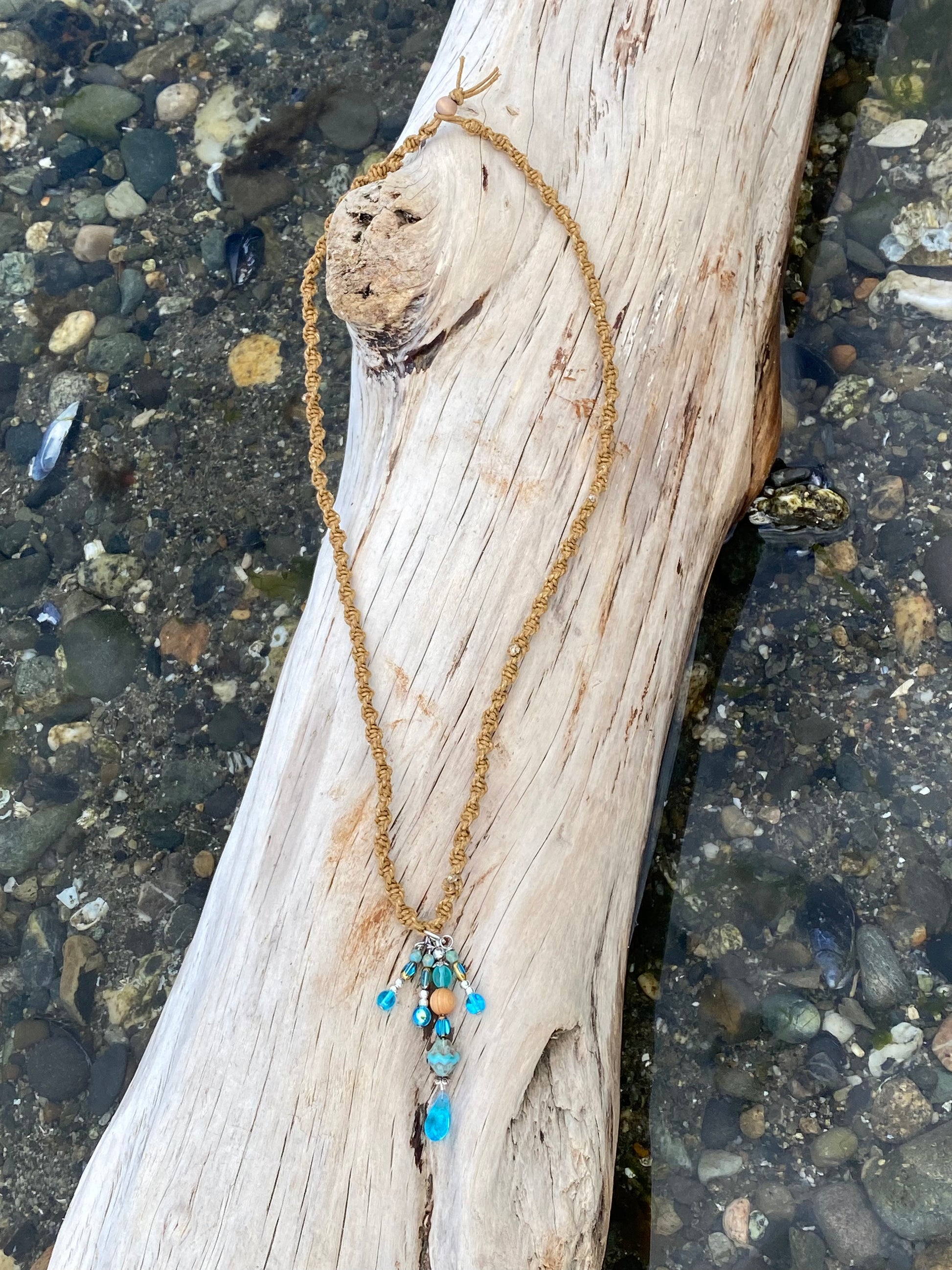 Boho Braided necklace, with Blue Dangle,  ocean beads, on  a piece of driftwood